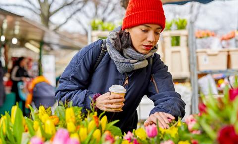 Person looking at spring flowers at a market before the Easter long weekend.