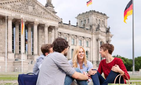 German language students try their skills with locals while having a picnic in front of the Reichstag in Berlin.