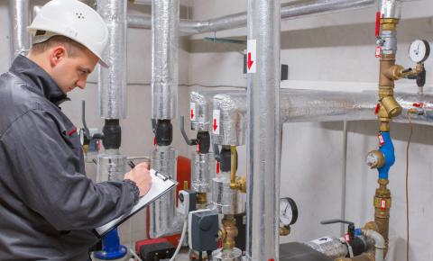 Heating, ventilating and air conditioning (HVAC) technician makes notes about an installation.
