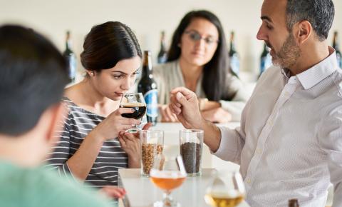 Hospitality students participating in a guided beer tasting flight with their instructor.