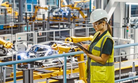 Person reading their tablet in an smart manufacturing plant.