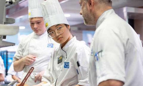 Culinary arts students get prepartion tips from their instructor as they cook in the state-of-the-art labs.