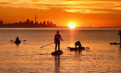 People enjoying the Labour Day weekend while paddle boarding on Lake Ontario.
