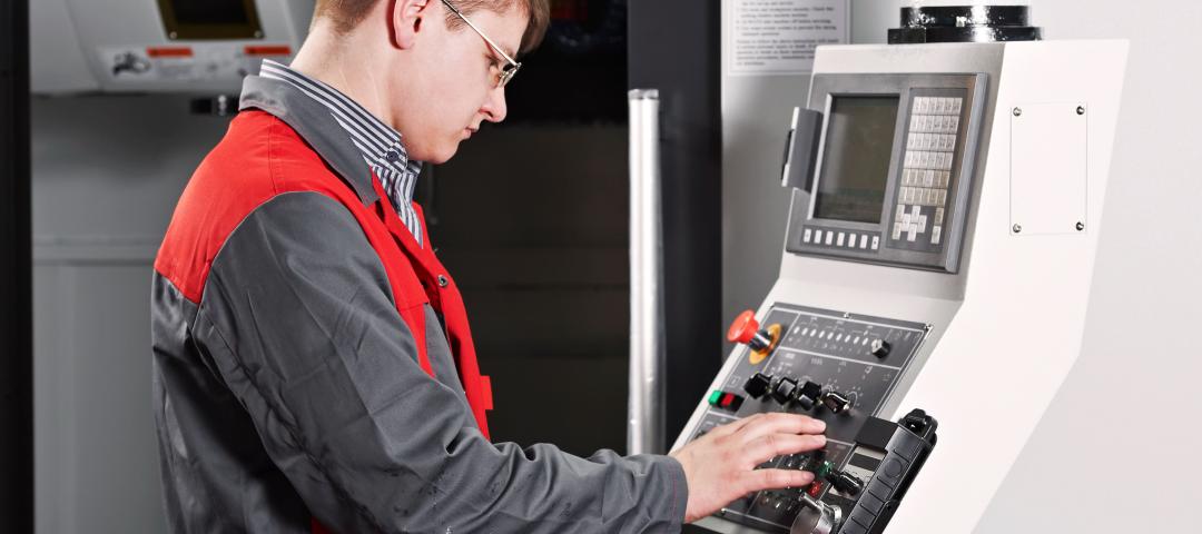 Operator checks the controls panel for an automated industrial manufacturing process.