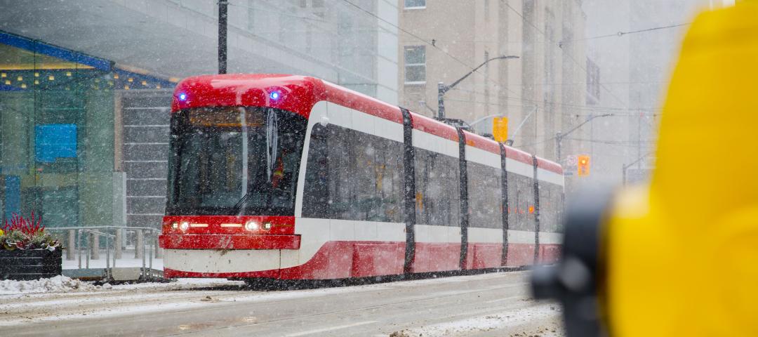A Toronto street car traversing through the city during a snowstorm.