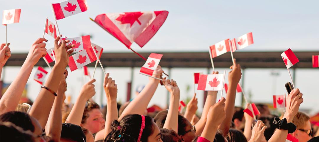 Happy Canadians waving flags as they celebrate Canada Day.