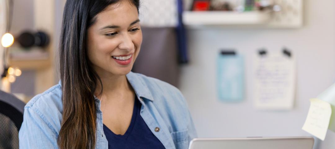 Person in a home workroom signing up online for a continuing education course.