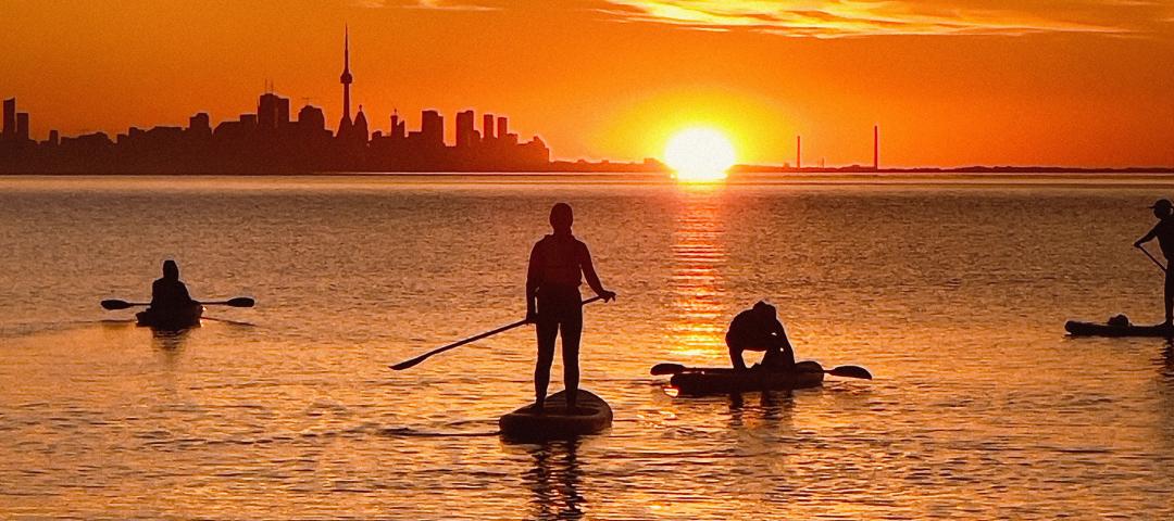 People enjoying the Labour Day weekend while paddle boarding on Lake Ontario.